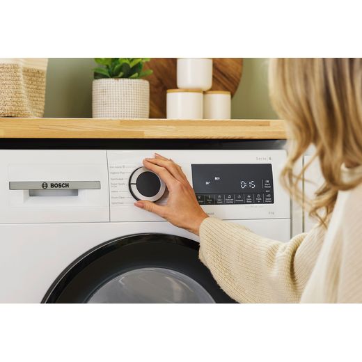 Bosch Series 6 WGG24400GB 9kg Washing Machine with 1400 rpm - White - Person turning setting on shot
